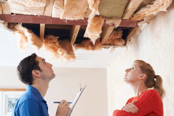 water damage signs to watch out for- man and woman looking at damaged ceiling