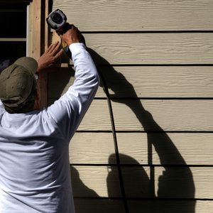 carpenter installing siding replacement